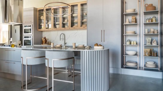 Uma ilha central pode servir como espaço extra para preparo de alimentos, armazenamento e refeições rápidas.